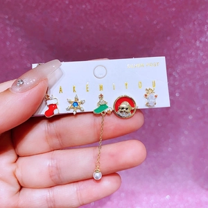 Detalle del juego de pendientes navideños con árbol de esmalte, copo y reno