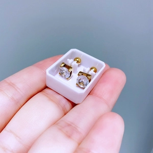 Details von goldenen Titanstahl-Ohrringen mit rundem Zirkonia in klassischer Krappenfassung