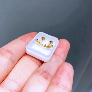 Makrofoto der goldenen T-Smile Titanstahl Ohrstecker mit Schraubverschluss auf weißer Basis