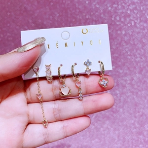 Gros plan d'un ensemble de 6 boucles d'oreilles dorées avec zircons cœur roses