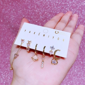 Vue détaillée du lot de 6 boucles d'oreilles dorées avec pendentifs cœur, étoile et planète