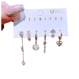 Set de 6 boucles d'oreilles dorées avec coeurs et zircons mauves sur carte de support