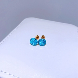 Nahaufnahme von 8mm himmelblauen Kristallohrringen auf einer weißen Schmuckschatulle