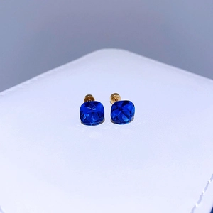 Nahaufnahme der blauen Kristallohrstecker mit Goldschliff auf weißem Schmuckkästchen