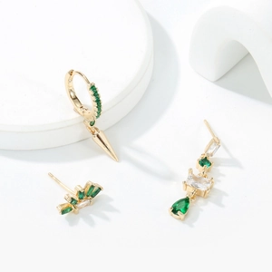 Three-piece set of gold earrings with emerald green zircons and geometric pendants
