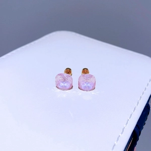 Makrodetail der 8mm rosa Zirkon-Ohrstecker auf einer weißen Schmuckschatulle aus Leder