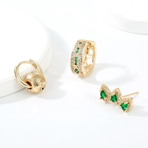 Detailed macro view of gold-plated green zircon hoop earrings set on white display