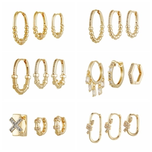Golden earrings set with green cubic zirconia and geometric hoop designs for women