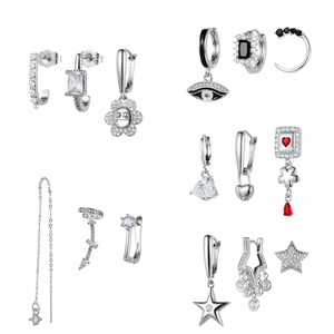 Silver earring set with green zircon, pearls, and star charms on a clean white background