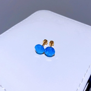 Nahaufnahme von 8mm runden blauen Kristallsteckern mit poliertem goldfarbenem Stahlverschluss
