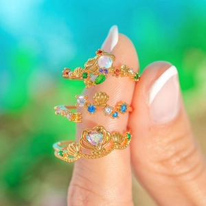 Detail-Makroansicht von drei vergoldeten Ozean-Ringen mit farbigen Zirkon-Steinen