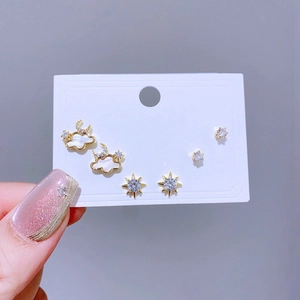 Nahaufnahme von elegantem Gold-Ohrring-Set mit Stern, Mond, Wolke und Zirkonia-Steckern