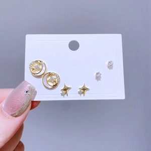 Nahaufnahme des goldfarbenen Ohrstecker-Sets mit Sternen und Zirkon auf weißer Karte