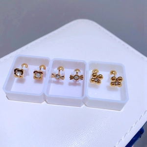 Drei Paar goldene Ohrstecker mit Kleeblatt- und Schleifenmotiv und klaren Kristallen