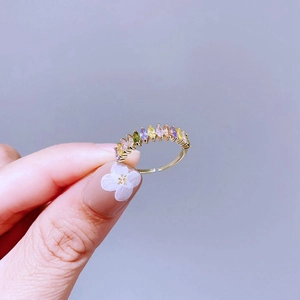 Nahaufnahme eines goldenen Rings mit bunten Zirkonia im Marquise-Schliff und Krallenfassung