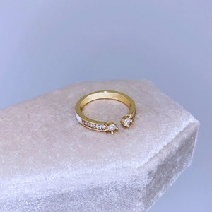 Dettaglio anello aperto dorato con pietre di zircone su espositore in velluto