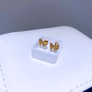Makroaufnahme von goldenen Schleifen-Ohrsteckern mit weißen Zirkonia in weißer Box