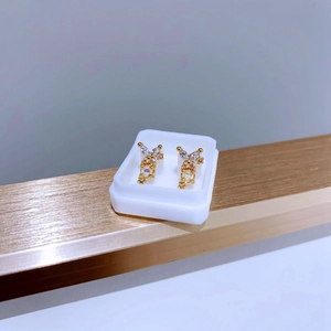 Detailansicht der goldenen Schmetterlingsohrringe mit bunten Zirkonia und Mikro-Inlay
