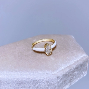 Anello regolabile dorato con zircone marquise e smalto bianco su sfondo azzurro