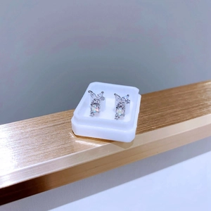 Makro-Detail des Schmetterling-Ohrrings mit Zirkonia und Opal-Zentralstein auf Stativ