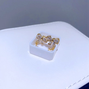 Nahaufnahme goldener Schleifenohrringe mit Zirkonia und Sternanhänger in Geschenkbox