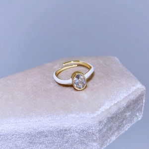 Dettaglio anello regolabile placcato oro con smalto bianco e zircone ovale lucido