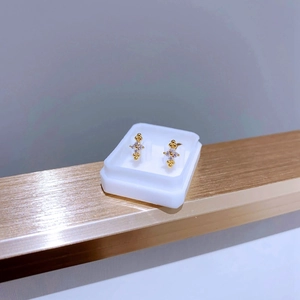Détail de clous d'oreilles étoile dorés avec zircone sur un plateau de présentation
