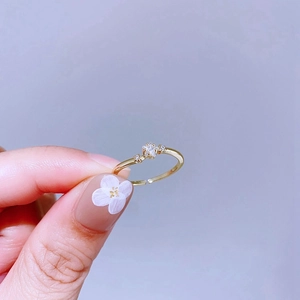 Nahaufnahme eines goldenen Rings mit Stern-Zirkonia und feinen Diamantakzenten an der Hand