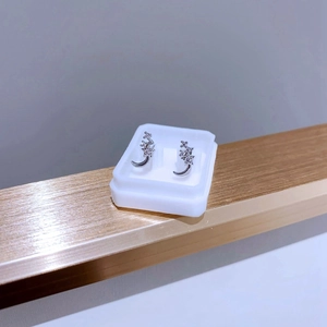 Vue détaillée des boucles d'oreilles lune et étoile argentées avec incrustation de zircon