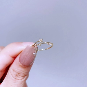 Makroaufnahme eines verstellbaren vergoldeten Rings mit Blumenmotiv und kleinen Kristallen
