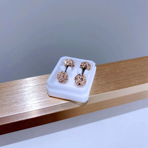 Macro shot of rose gold titanium screw back stud earrings with full white rhinestones