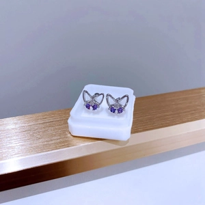 Detailansicht der hohlen Schmetterling-Ohrstecker mit lila Zirkonia-Steinen