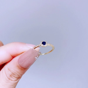 Detailansicht eines Luxus-Halo-Rings mit dunkelblauem Edelstein und Goldband