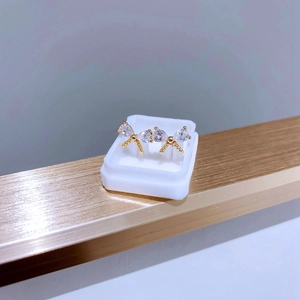 Vue détaillée de boucles d'oreilles papillon dorées avec zircones dans un écrin blanc