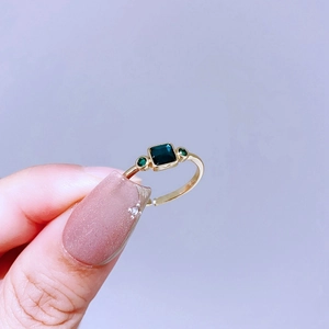 Detail eines verstellbaren Goldrings im Vintage-Stil mit grünem Edelstein und Zirkonia