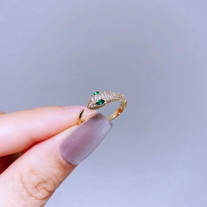 Luxurious gold snake ring with sparkling white cubic zirconia and green gemstone eyes