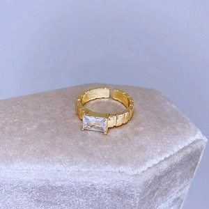 Anello dorato regolabile con zircone rettangolare e fascia a trama geometrica