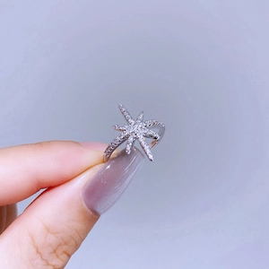 Elegant silver starburst ring featuring sparkling zircon stones and an open band design