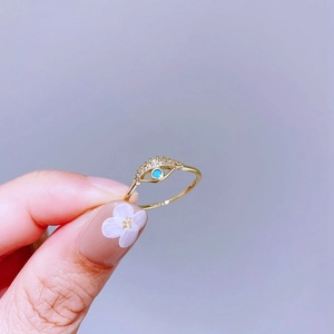 Detail eines goldenen Augen-Rings mit Türkis-Zentrum und funkelnden Zirkonia-Wimpern