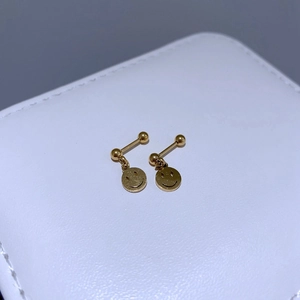 Makroansicht goldener Barbell-Ohrstecker aus Edelstahl mit hängenden Smiley-Anhängern