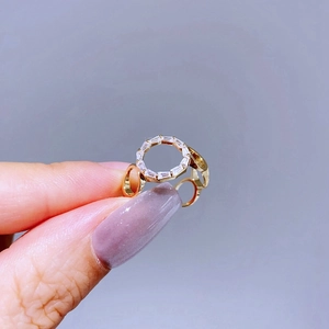 Detailed view of a gold hollow link ring featuring a geometric cluster of zircon stones