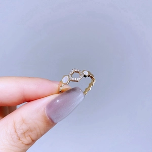 Macro view of gold honeycomb ring with hexagonal mother-of-pearl and micro-pave crystals