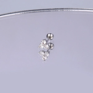 Detail der Edelstahl-Ohrstecker mit Zirkonia-Blume und Schraubverschluss auf Spiegelglas