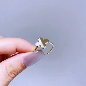 Detailed close-up of a golden four-leaf clover ring with white mother of pearl inlay