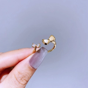 Detailed close-up of a gold bow ring with sparkling cubic zirconia and white pearl