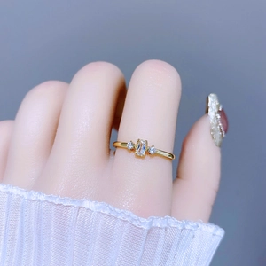 Eleganter goldener Ring mit rechteckigem Zirkonia und zwei Seitensteinen für Damen