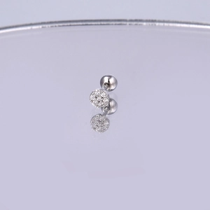 Makroaufnahme von Silber-Stahlstecker mit funkelndem Zirkonia auf spiegelnder Fläche