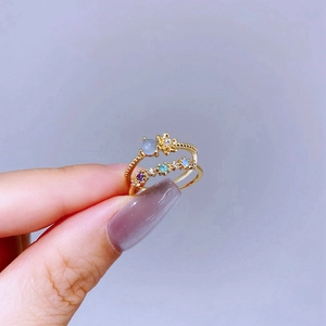Macro detail of gold stackable rings featuring blue gemstone and colorful zircons