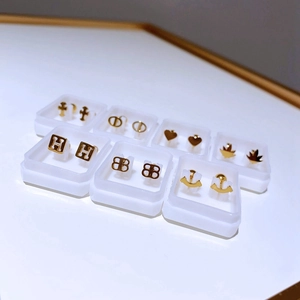 Detail-Set aus goldenen Titanstahl-Ohrsteckern in einzelnen klaren Geschenkboxen