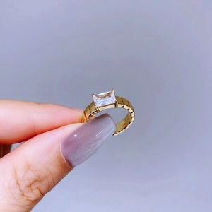 Detailed macro shot of a gold textured ring featuring a rectangular zircon stone inlay